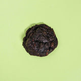 Vegan Raspberry Dark Choc New York Cookie by Crumbs & Doilies on green background, made with black cocoa and raspberries.